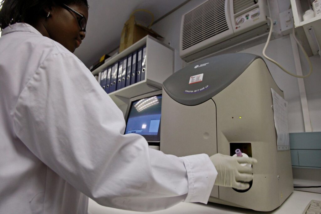 2P88H4H Health worker Xolisa Madikane tests blood for the HIV virus at a container lab next to the Gugulethu Community Health Clinic in Gugulethu on the outskirts of Cape Town, South Africa, Tuesday, July 21, 2009. South Africa launched a high-profile trial of an AIDS vaccine created by its own researchers Monday, a proud moment in a nation where government denial, neglect and unscientific responses have helped fuel the world's worst AIDS crisis. (AP Photo/Schalk van Zuydam)