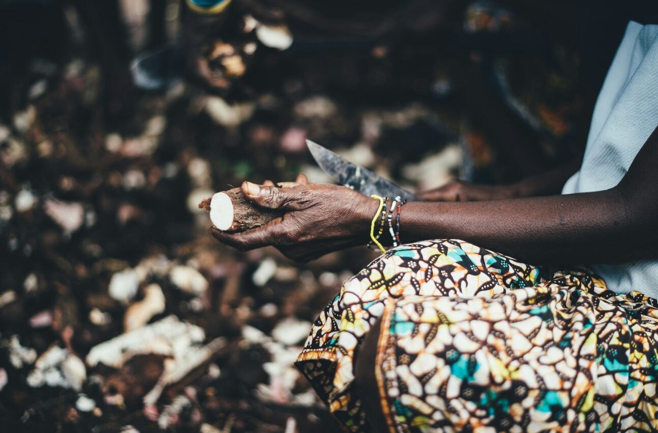 An African woman peeling a cassava tuber