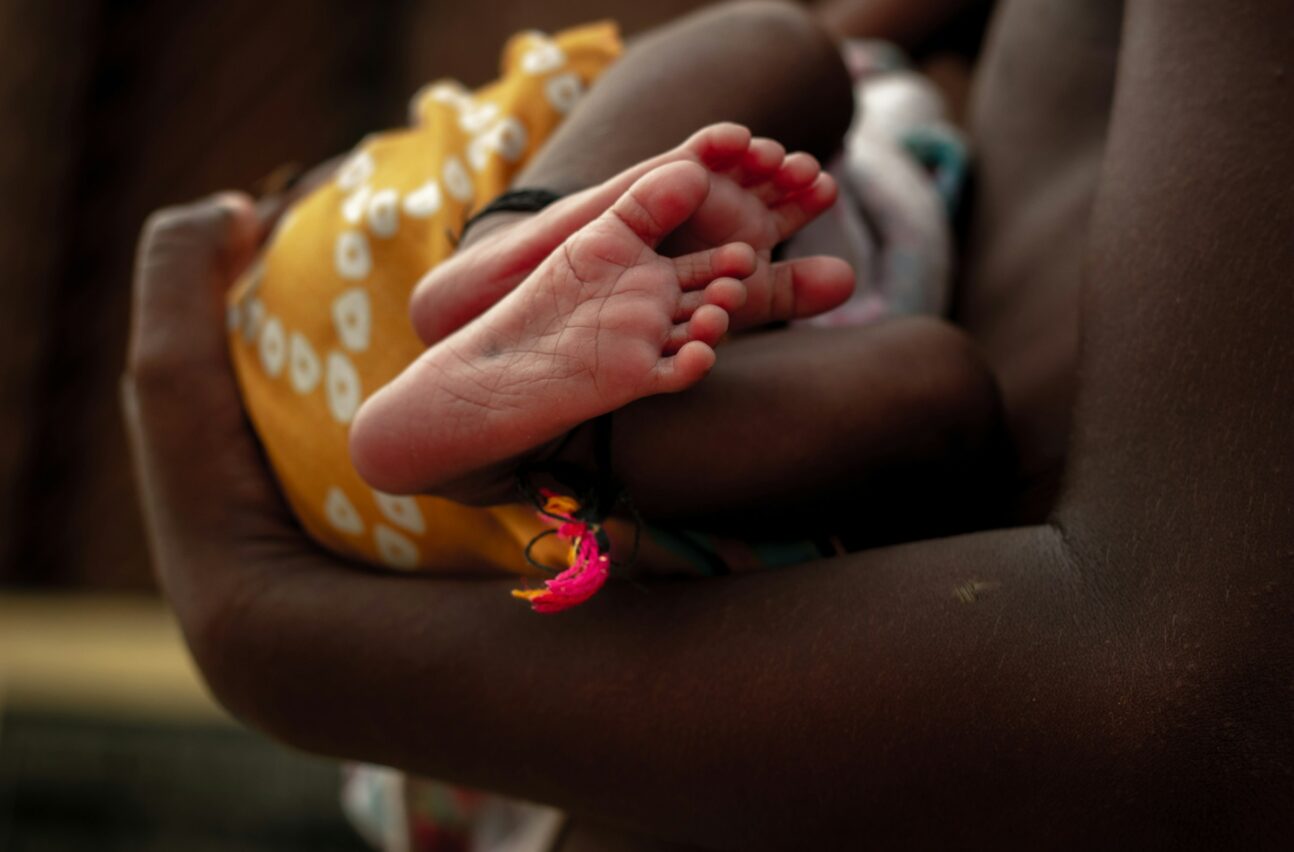 African boy holding a newborn baby